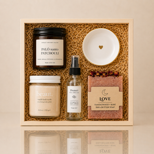 Wedding gift set in a wooden keepsake box featuring a Palo Santo Patchouli candle, vanilla body scrub, protect room and body spray, love sandalwood rose shea butter soap, and a white trinket dish with a gold heart