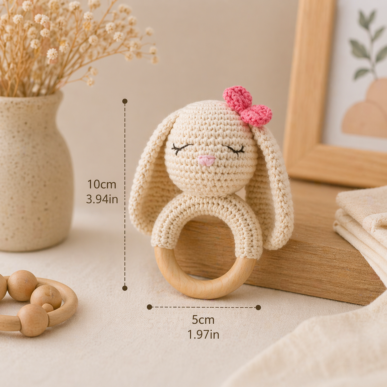 Crochet bunny teether with wooden ring and size dimensions shown in centimeters and inches