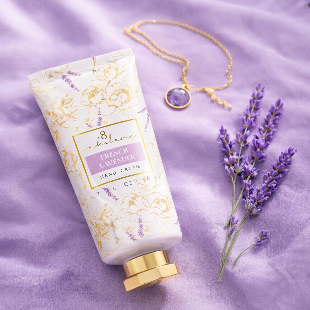 French Lavender hand cream styled on soft lavender fabric with fresh lavender sprigs and a delicate gold necklace in an elegant flat lay product photo